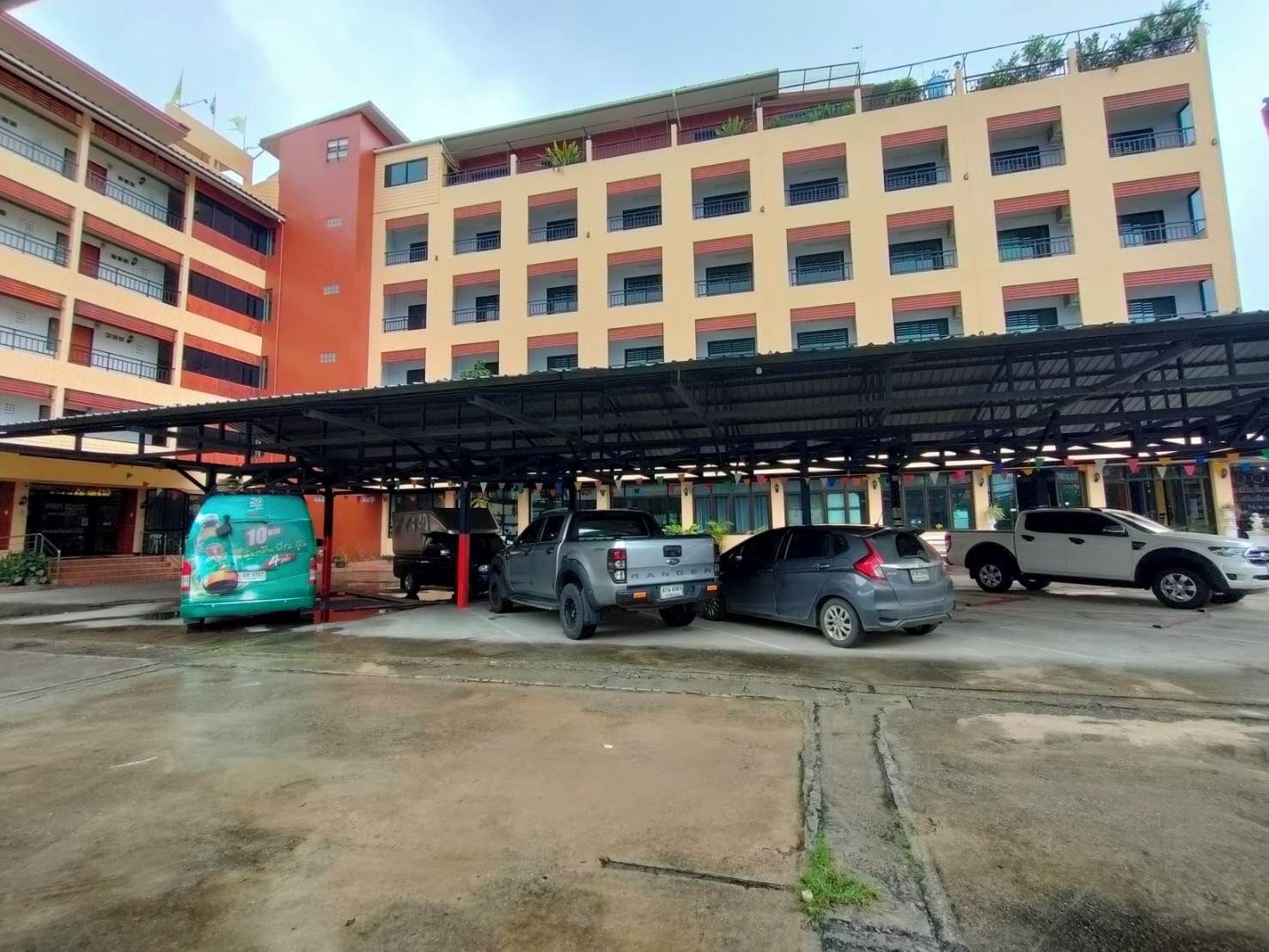 A multi-story hotel with a covered parking area.