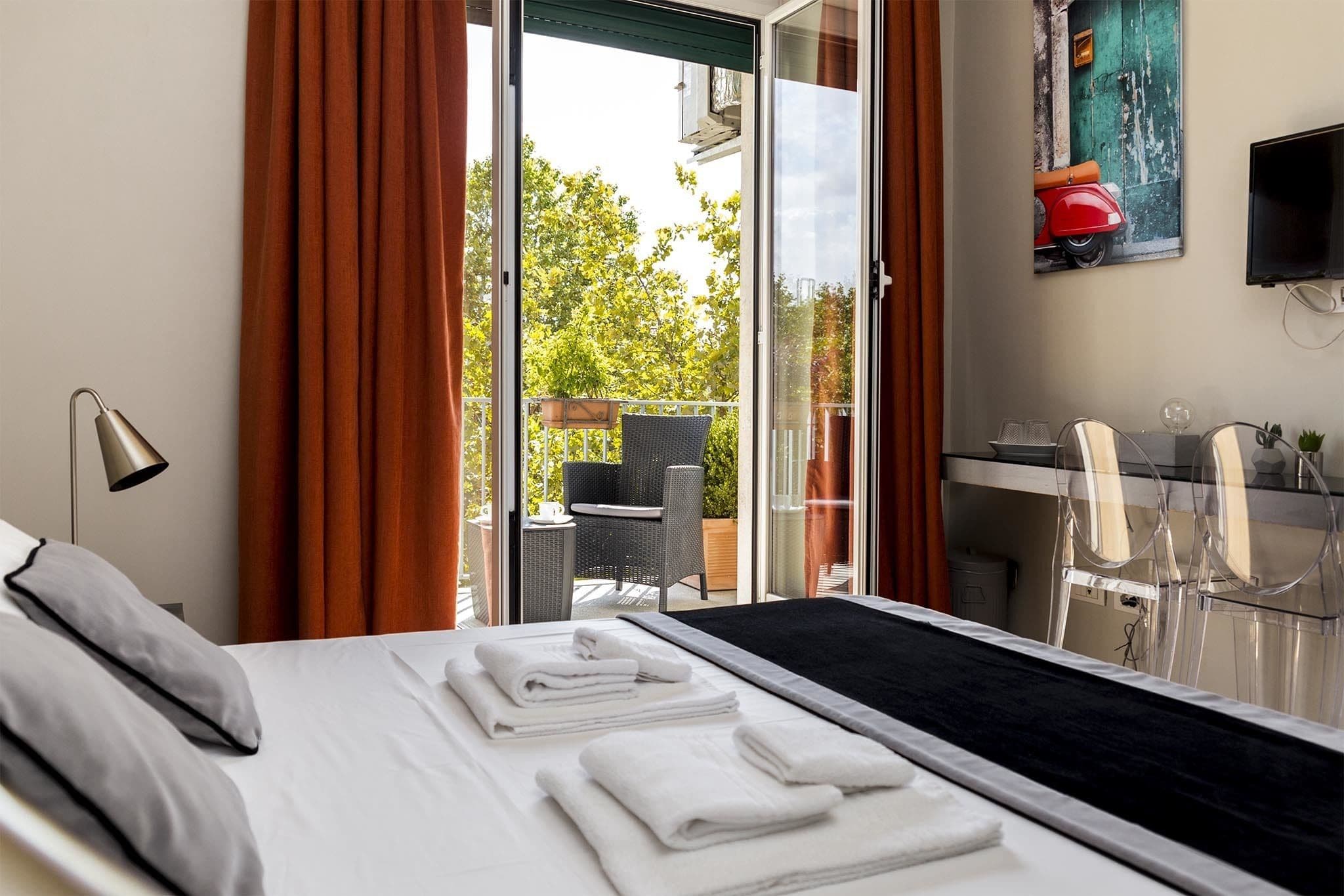 A hotel room with a bed, a desk, and a chair.