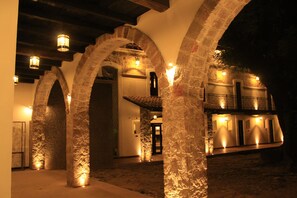 Un edificio de piedra con arcos en las entradas y un balcón.