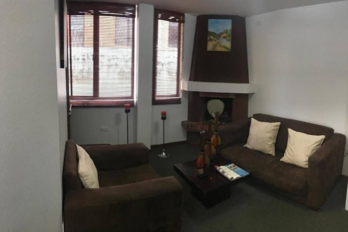 A living room with two brown sofas, a coffee table, and a fireplace.