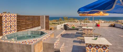 A rooftop pool, pool umbrellas, pool loungers