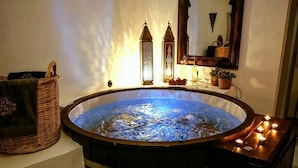 A hot tub with a wooden frame, a wicker basket, and a candle holder. - Dandy Cave Villa-Private Luxurious Waterfall Pool - Hot Tub (Santorini)