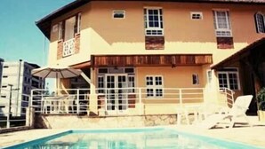 A two-story building with a swimming pool in front. - Pousada Bariloche (Teresópolis)