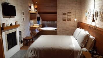 Ein Schlafzimmer mit einem großen Bett, einem Kamin und einem an der Wand befestigten Fernseher.