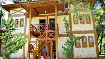 A two-story building with a wooden balcony, a staircase, and a fire extinguisher.