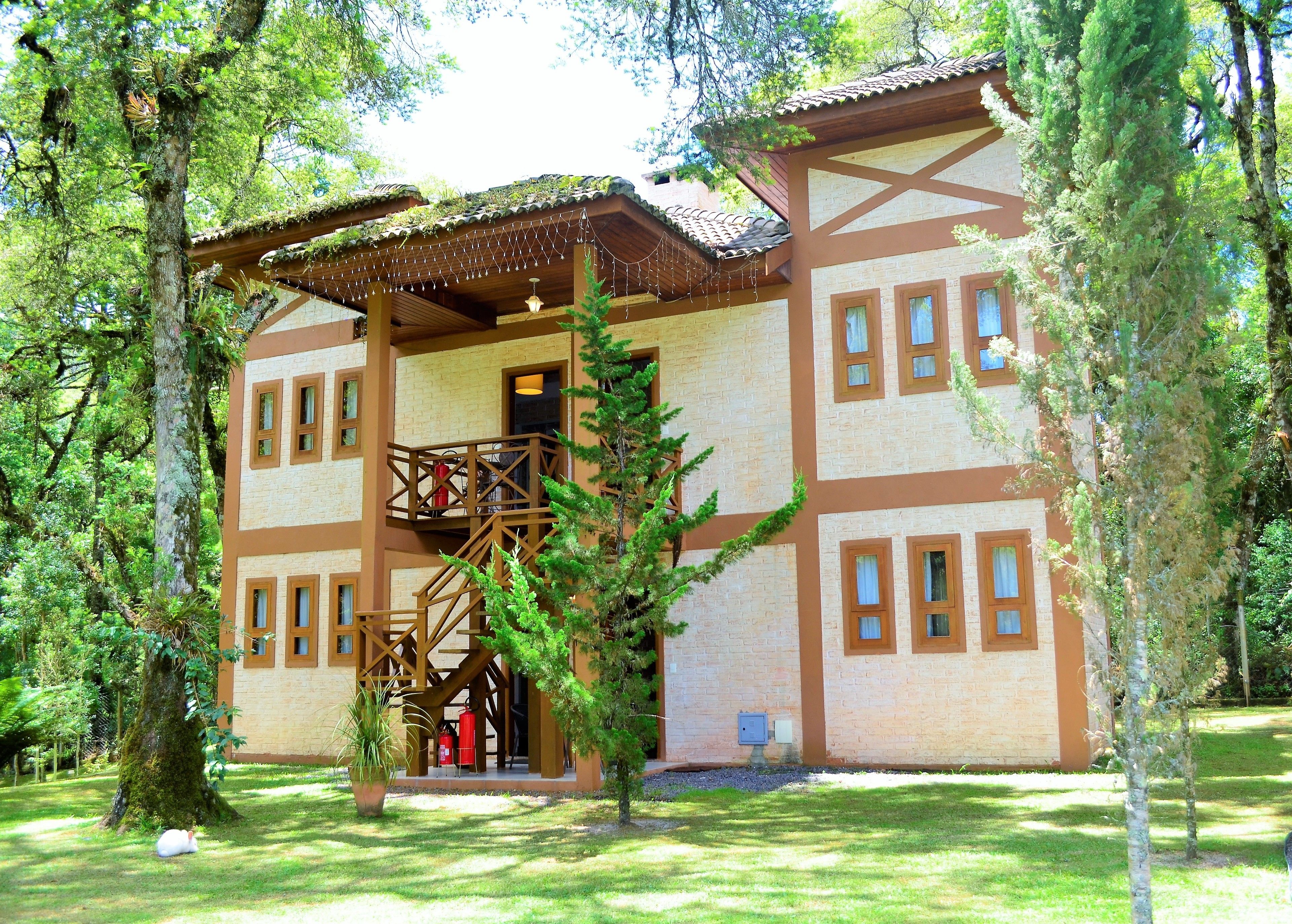 Un bâtiment à deux étages doté d’un balcon en bois, de nombreuses fenêtres et d’une façade en briques.