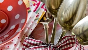 A table setting with a red polka-dotted plate, a checkered napkin, and a set of silverware. - The Old Manor House B & B (Westerham)