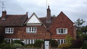 A two-story house with a stone facade, white-framed windows, and a visible chimney. - The Old Manor House B & B (Westerham)