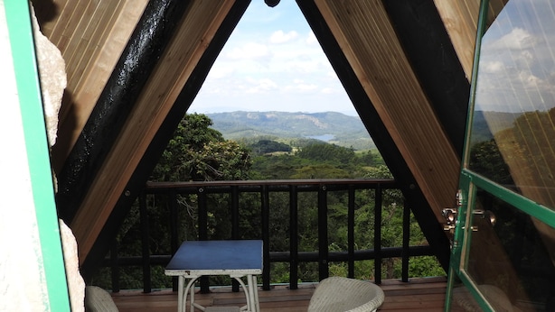 Eine Terrasse im Freien mit Tisch und zwei Stühlen mit Blick auf eine gebirgige Landschaft.