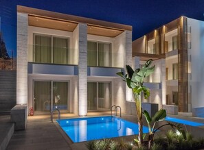 Un edificio moderno de dos pisos con una piscina al frente.