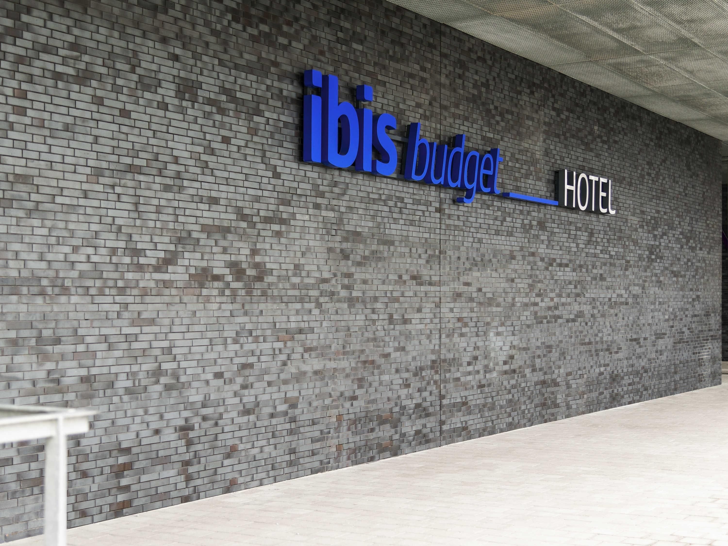 A hotel sign with the name "ibis budget" and the word "HOTEL" below it.