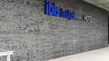 A hotel sign with the name "ibis budget" and the word "HOTEL" below it.