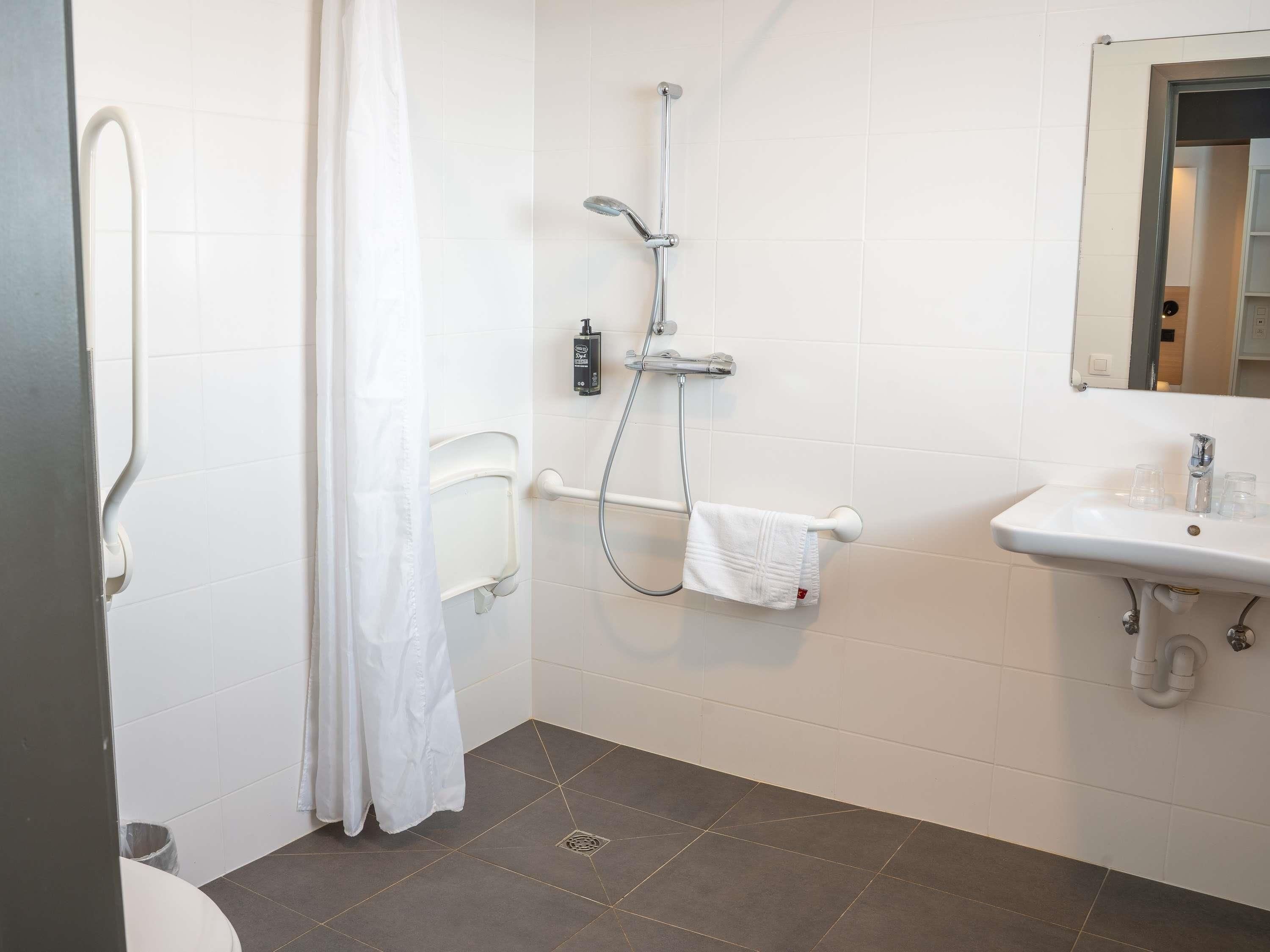 A bathroom with a shower, toilet, and sink.