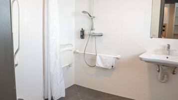A bathroom with a shower, toilet, and sink.
