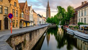 A canal with buildings on one side and a tower in the background. - ibis budget Blankenberge (Blankenberge)