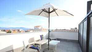 A rooftop terrace with a white umbrella, two white chairs, and a small table. - Hotel L´Escala Centre (L'Escala)