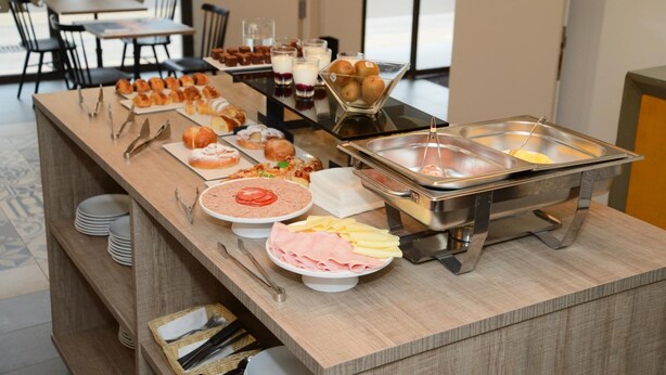 A buffet setup with various food items and utensils. - Hotel L´Escala Centre (L'Escala)