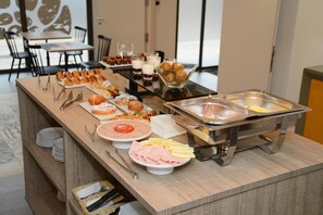 A buffet setup with various food items and utensils. - Hotel L´Escala Centre (L'Escala)