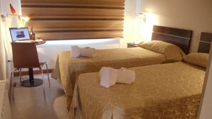 A hotel room with two beds, a desk, and a chair. - El Molle Hotel Boutique (Sarmiento)