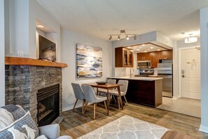 Enjoy meals in the spacious kitchen with an island and dining area featuring a wooden table and comfortable chairs.