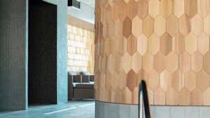 A modern indoor pool area with a hexagonal wooden wall and a clear pool.