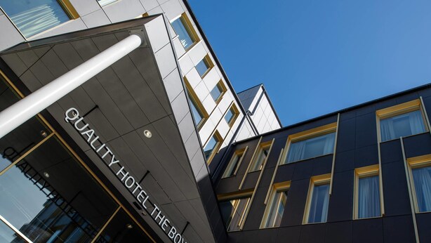 A modern hotel building with a prominent sign reading 'QUALITY HOTEL THE BOX.'