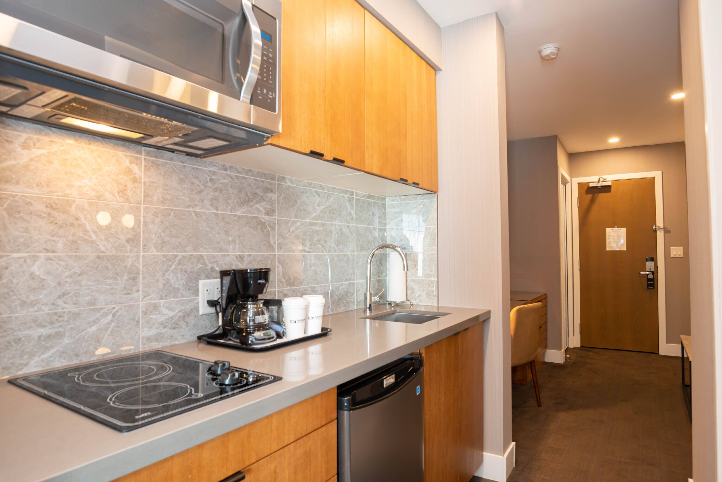 A modern kitchen with a built-in microwave, coffee maker, and dishwasher.