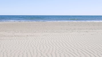 Una playa cerca, sillas reclinables de playa, sombrillas