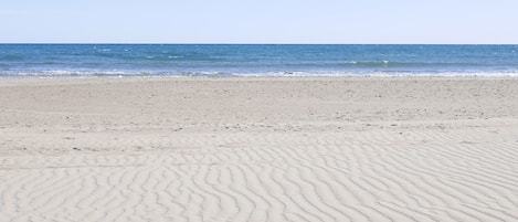 Vlak bij het strand, ligstoelen aan het strand, parasols, een strandbar