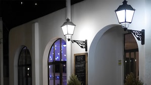A building with arched windows and a signboard indicating a bar and concert venue. - Camping Azahar (Benicassim)