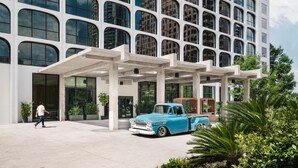 A modern building with a unique facade, a blue vintage car parked in front, and a person walking. - The LINE Austin (Austin)