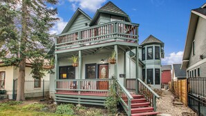 Ein zweistöckiges Haus mit Balkon, Veranda und einer Treppe, die zum zweiten Stock führt.