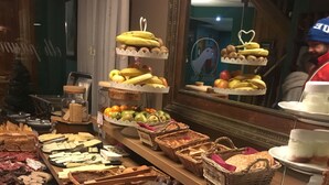 Un bufé con diversos alimentos, incluyendo pasteles, frutas y postres.
