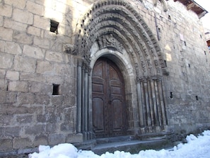 Un edificio de piedra con una puerta de madera grande y tallas intrincadas.