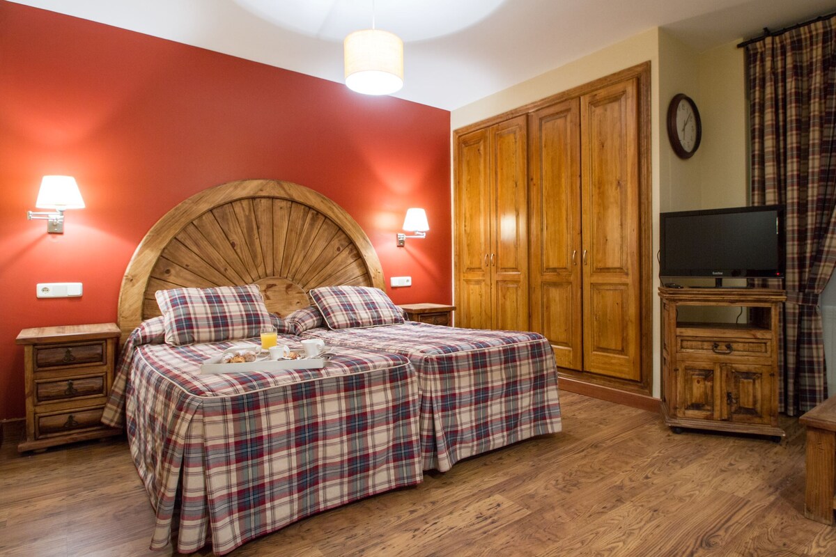 Une chambre à coucher comprenant un lit, une armoire en bois, une télévision et une table de chevet.