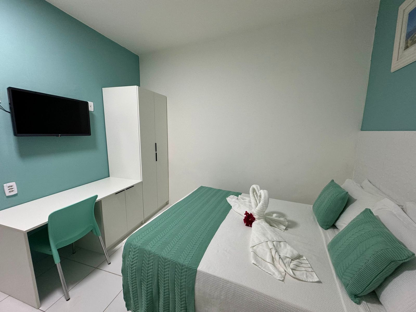Una habitación de hotel con una cama, un escritorio y un televisor.