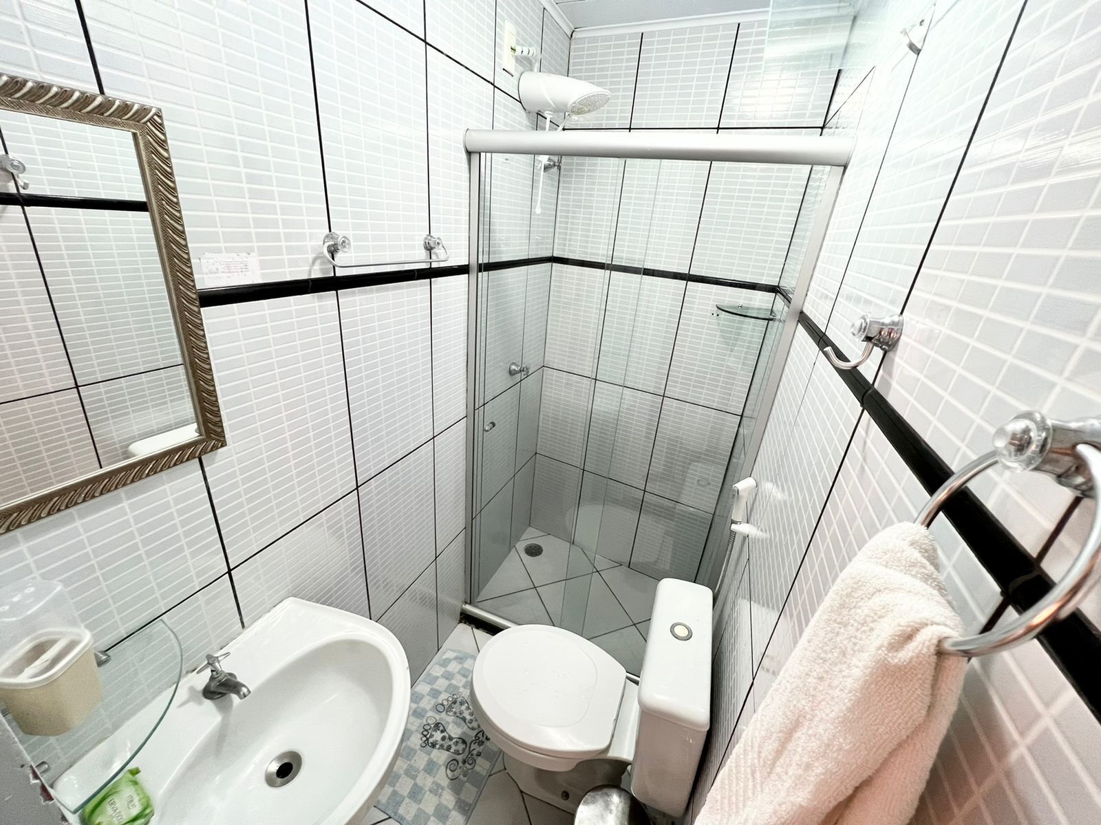 A bathroom with a white sink, toilet, and shower.