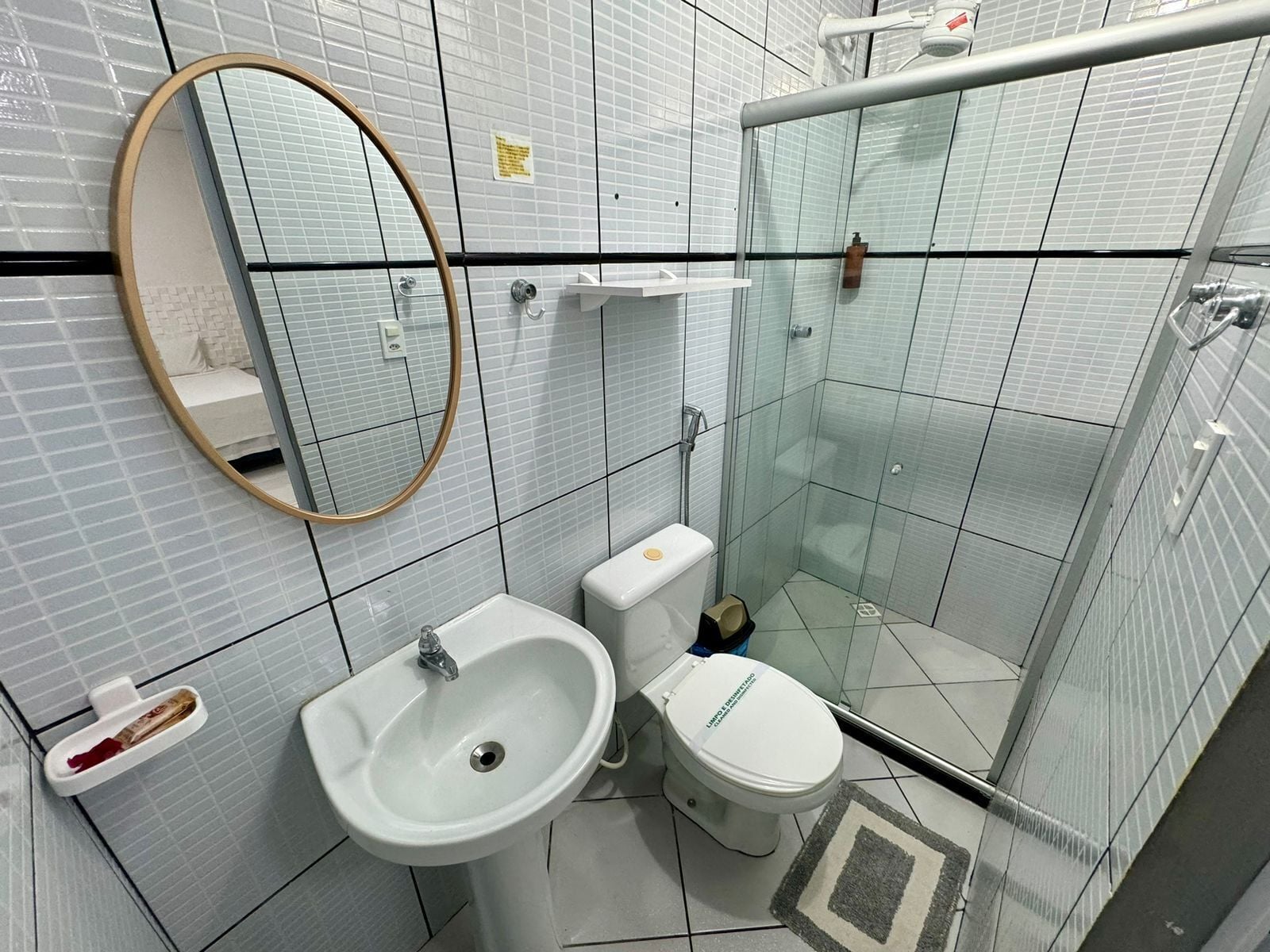 Ein modernes Badezimmer mit Waschbecken, Toilette und Duschkabine aus Glas.