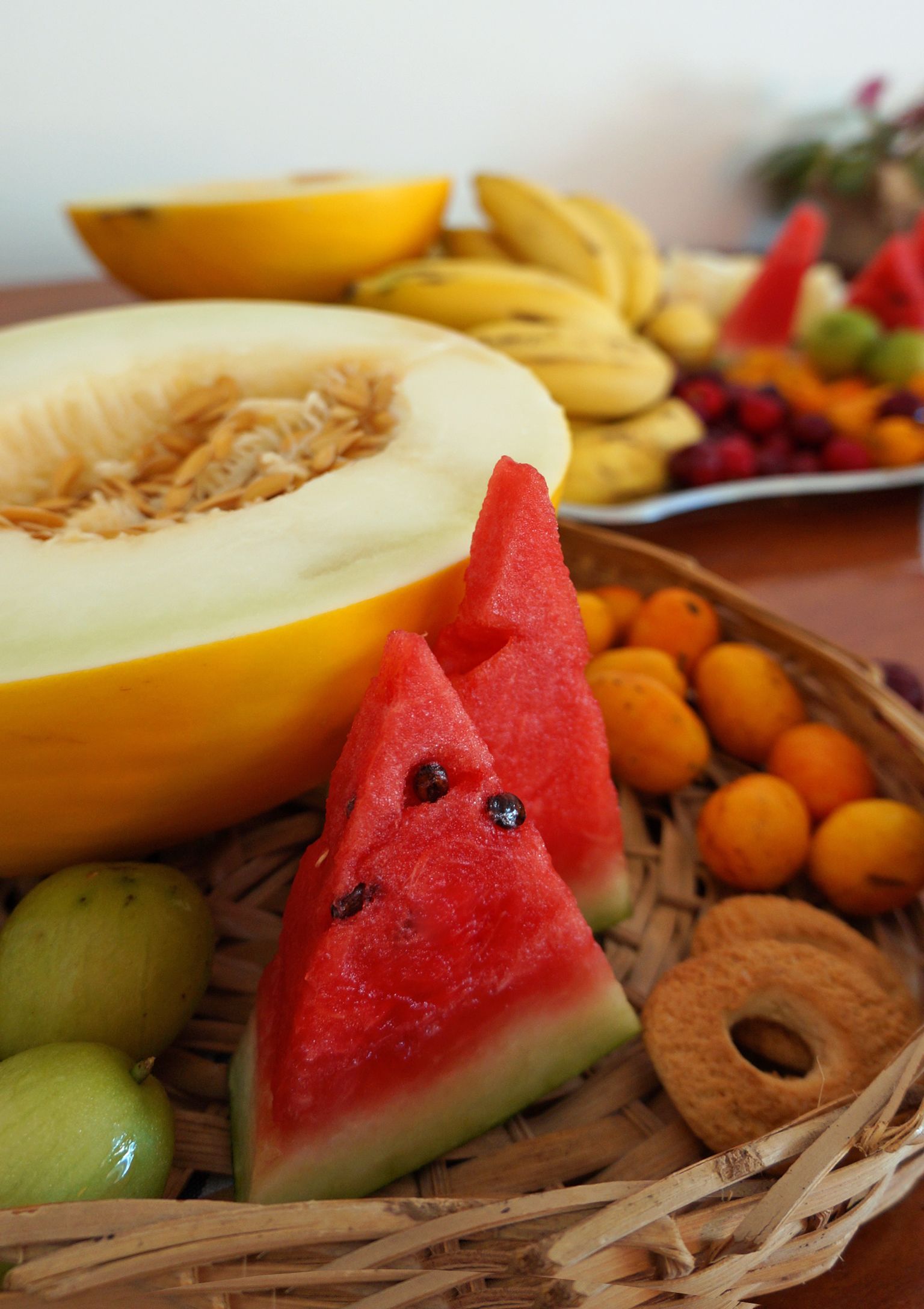 A fruit basket with various fruits including watermelon, bananas, and oranges.