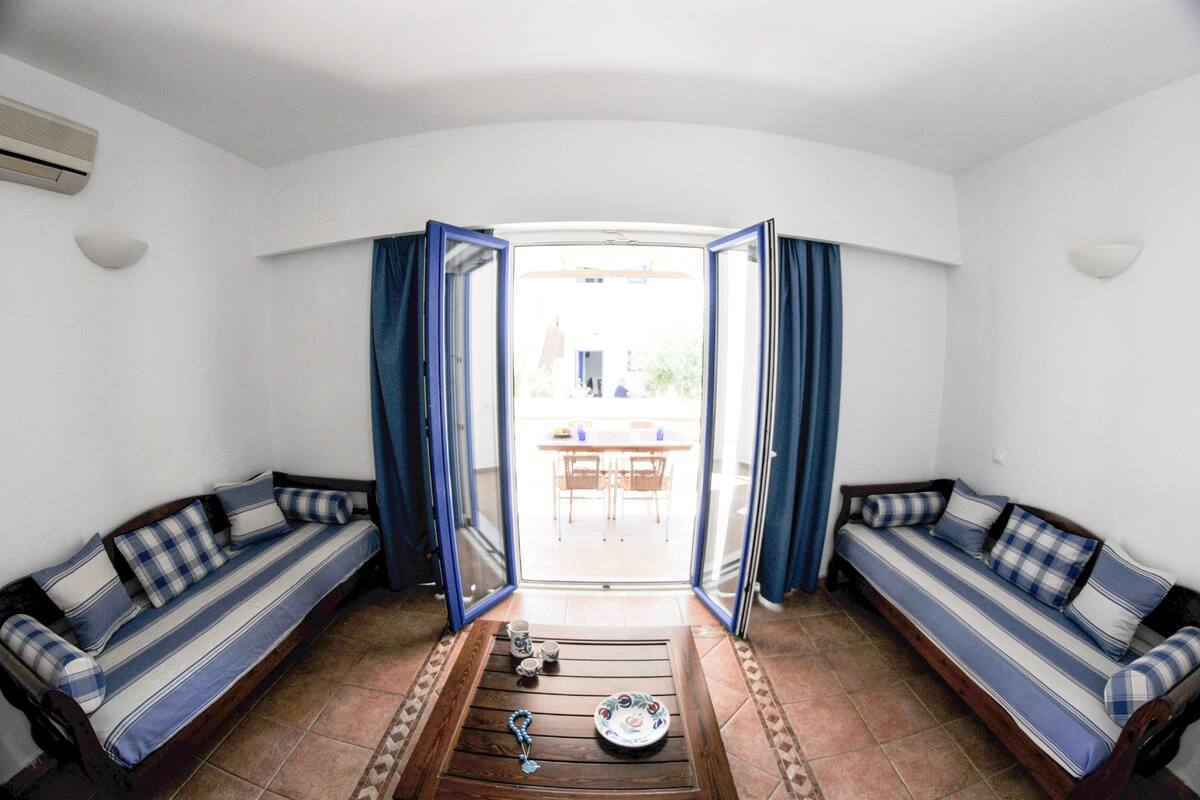 Una habitación con dos sofás orientados hacia un ventanal que da a un espacio al aire libre.