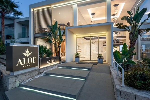 A modern hotel entrance with a sign for 'Aloe' and 'Asteri'. - _aloe Boutique And Suites (Apokoronas)