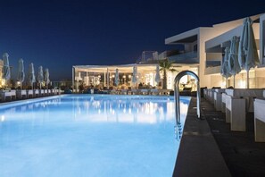 A swimming pool with lounge chairs and umbrellas, a bar area, and a modern building with large windows. - _aloe Boutique And Suites (Apokoronas)