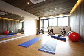 A gym with exercise equipment, mats, and a large window. - The HOTEL Well-hub Haneda (Formerly: Kawasaki King Skyfront Tokyu REI Hotel) (Kawasaki)