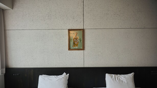 A hotel room with two beds, a headboard, and a wall-mounted artwork. - The HOTEL Well-hub Haneda (Kawasaki)
