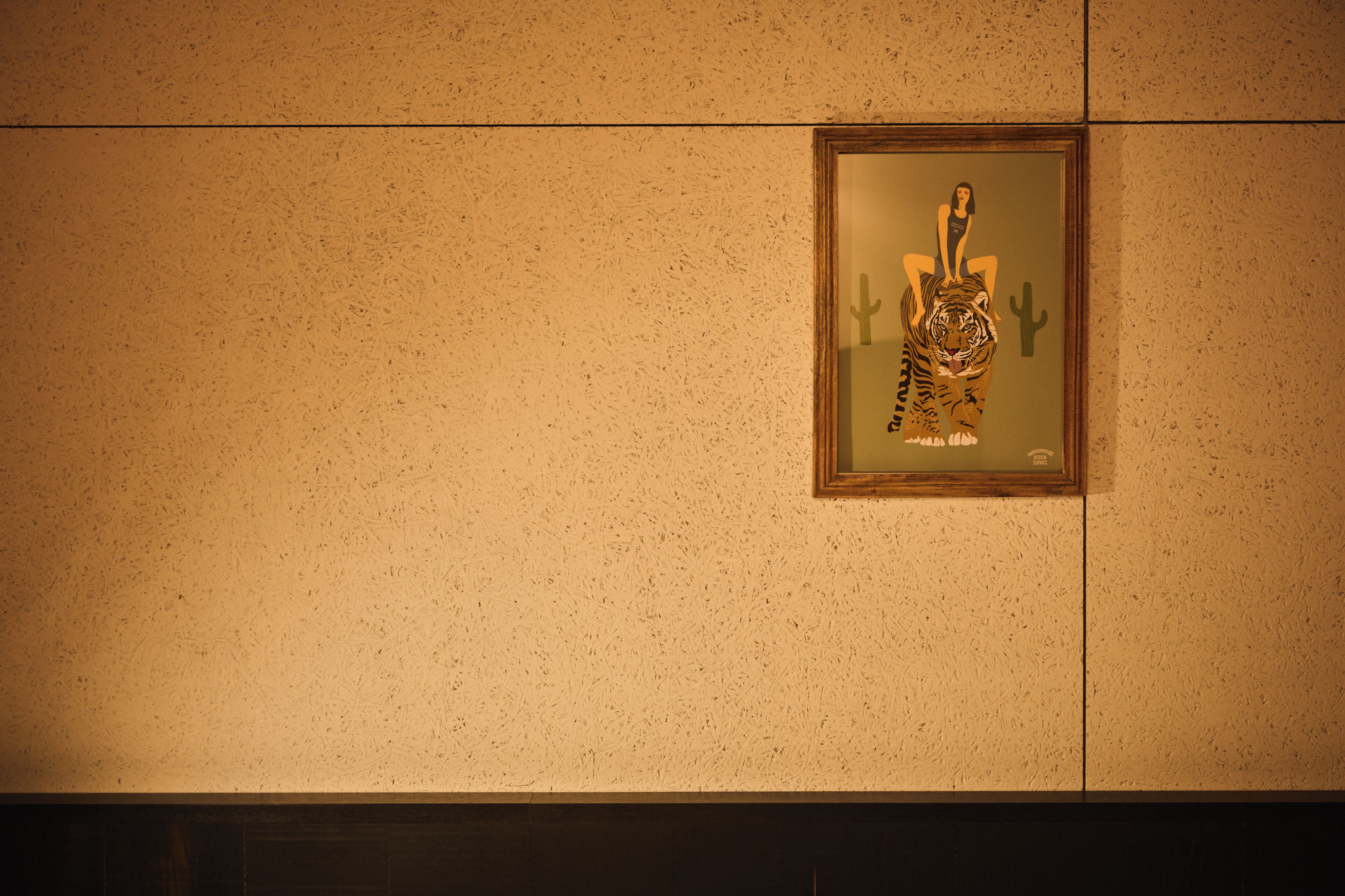 A framed artwork on a textured wall.
