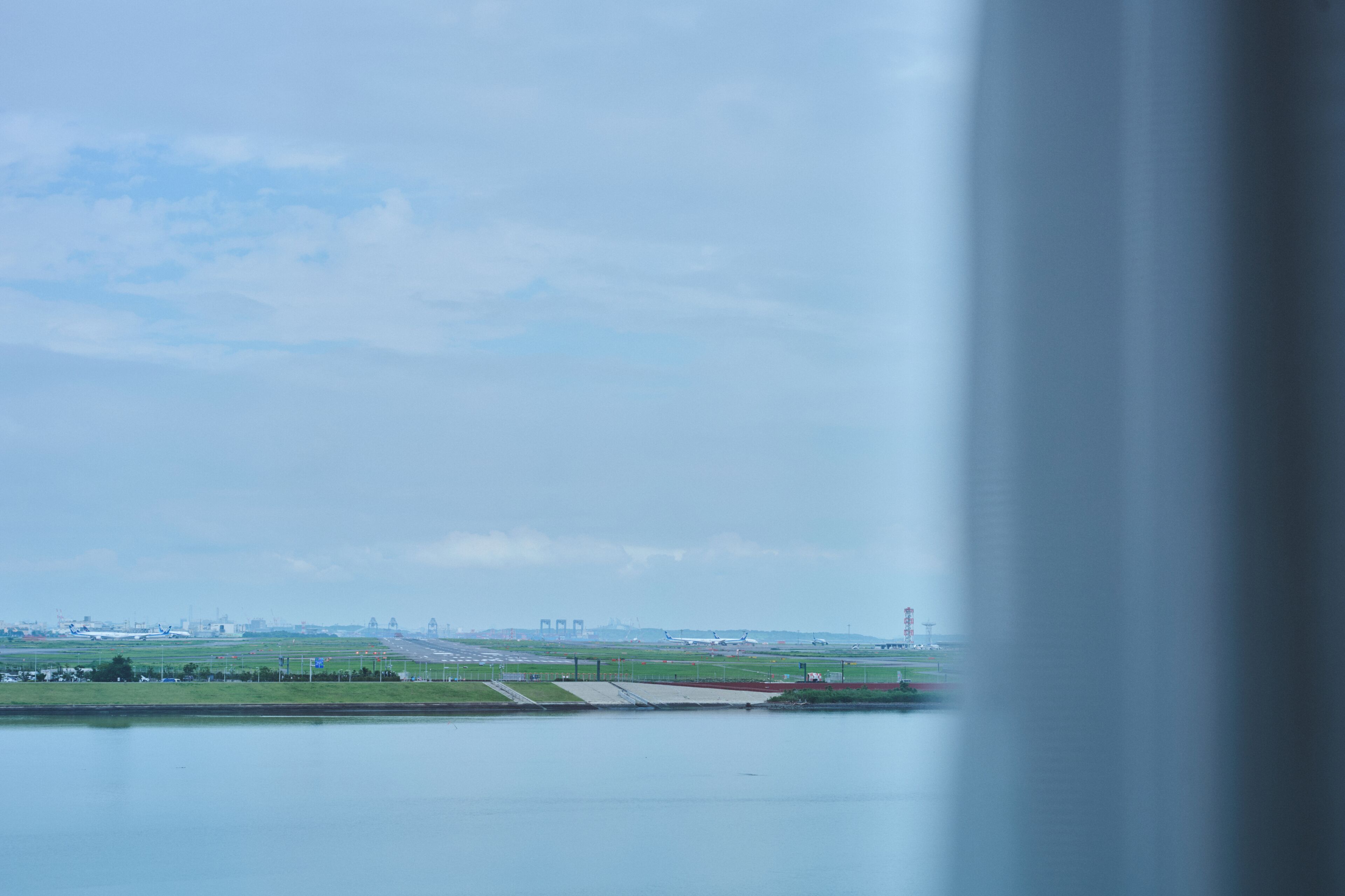 Vista de una pista de aeropuerto con aviones e infraestructura aeroportuaria.