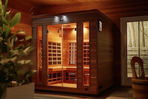 Uma sauna com exterior de madeira e portas de vidro, apresentando um banco e prateleiras no interior.