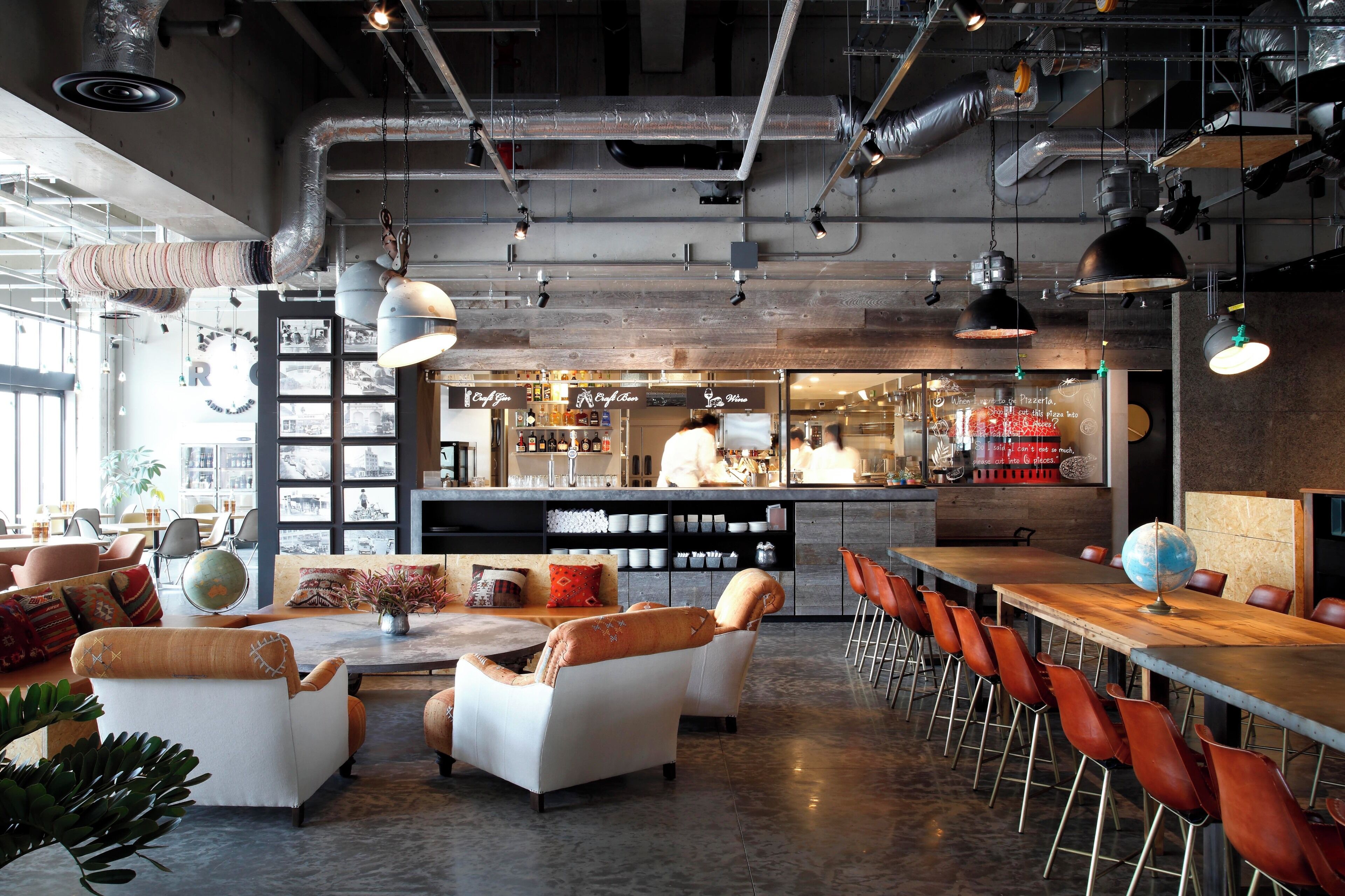 A modern bar area with seating and a kitchen in the background.