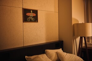 A hotel room with a bed, pillows, a wall-mounted picture, and a standing lamp. - The HOTEL Well-hub Haneda (Kawasaki)