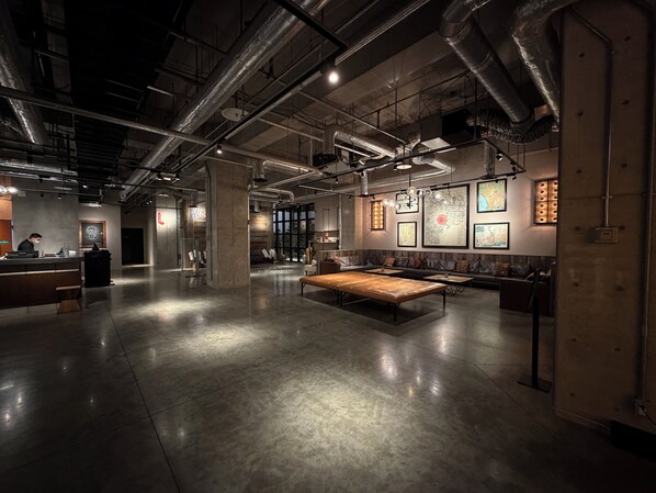 A spacious indoor area with a reception desk, seating area, and artwork on the walls.